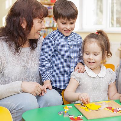 A caregiver with children at Apple Valley Childcare & Preschool