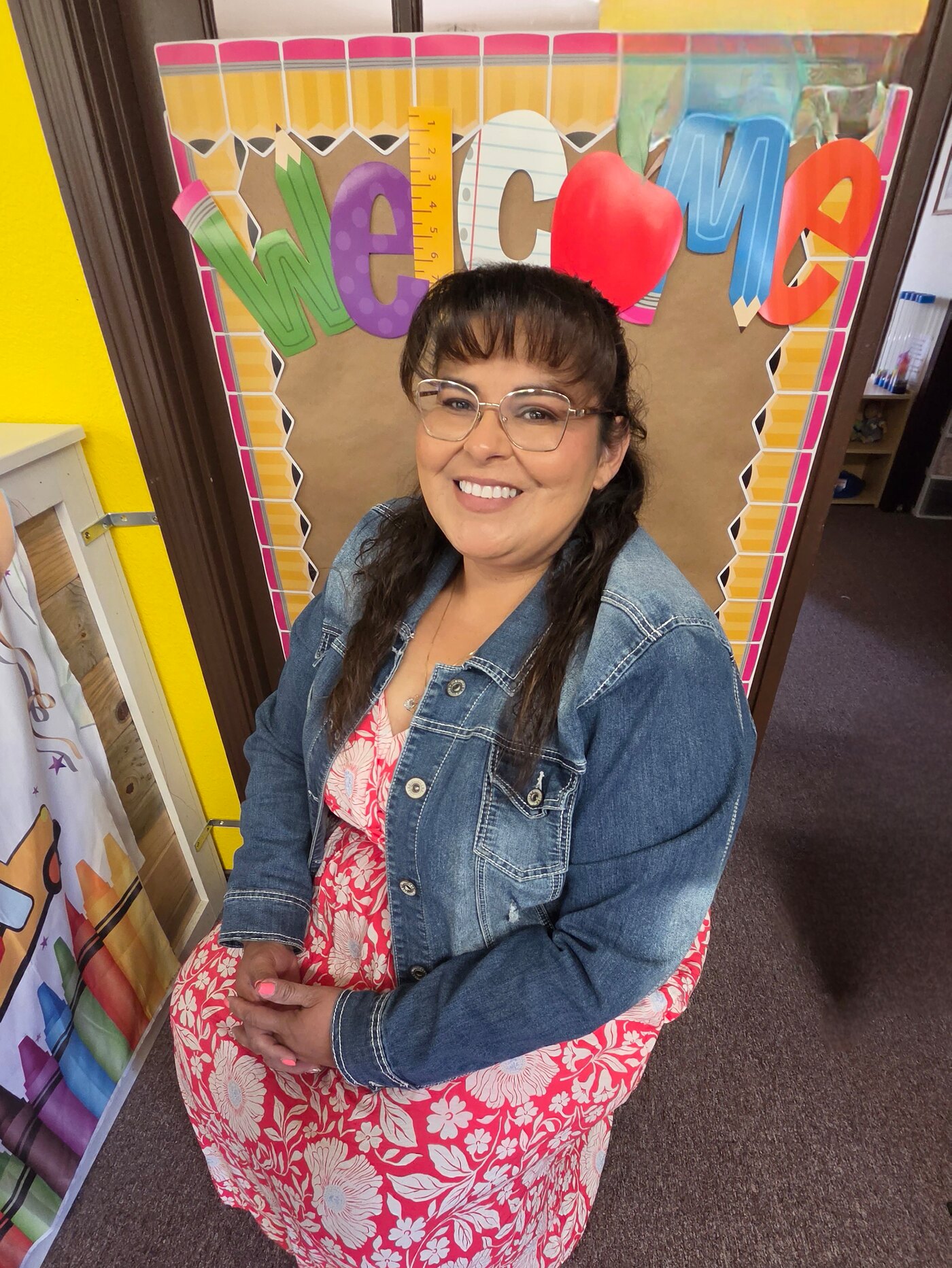 Angelica Sanchez seated on the welcome bench at the entrance to Apple Valley Childcare and Preschool
