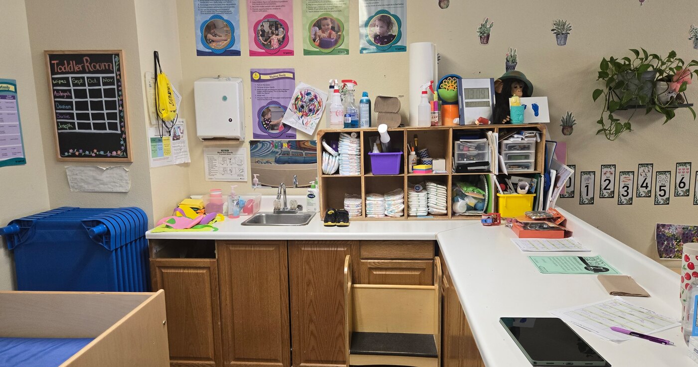The Apple Valley toddler room with its changing station, sink and labelled cubbies